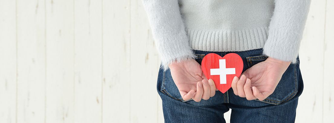 parte del cuerpo de una mujer con las manos en la espada sujetando un corazón rojo con una cruz 