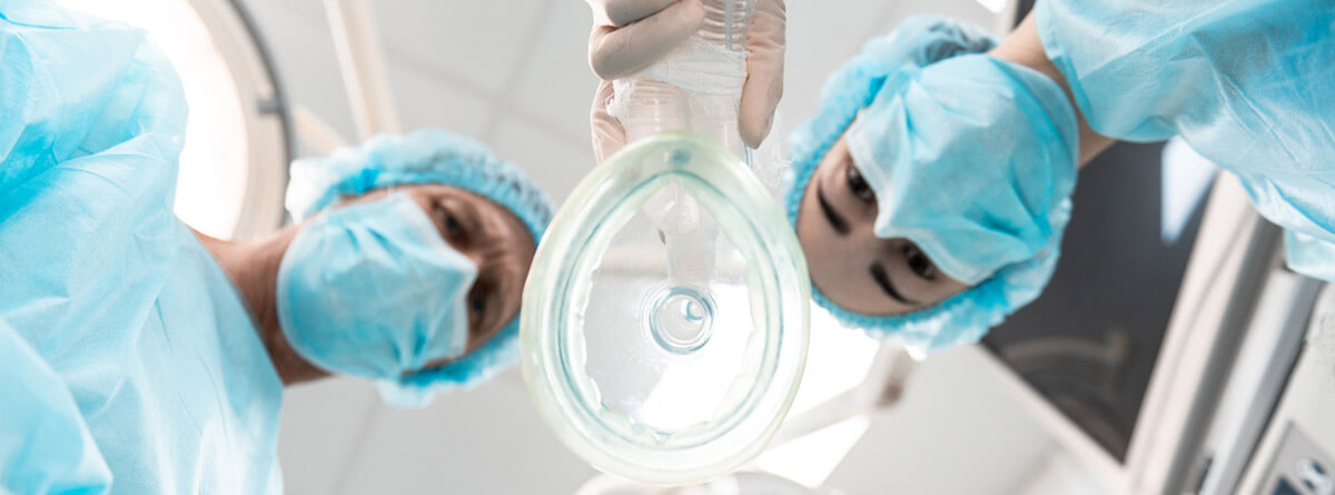 Anestesia en personas mayores: dos médicos en quirófano con una mascarilla anestésica