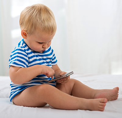 bebé sentado jugando con un móvil