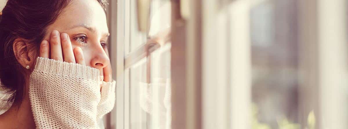 Decepción: mujer pensativa mirando por la ventana