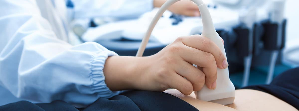 médico realizando ecografía a mujer embarazada