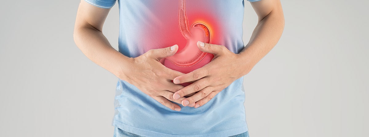 hombre con las manos en el abdomen con un dibujo del estómago en concepto de dolor abdominal