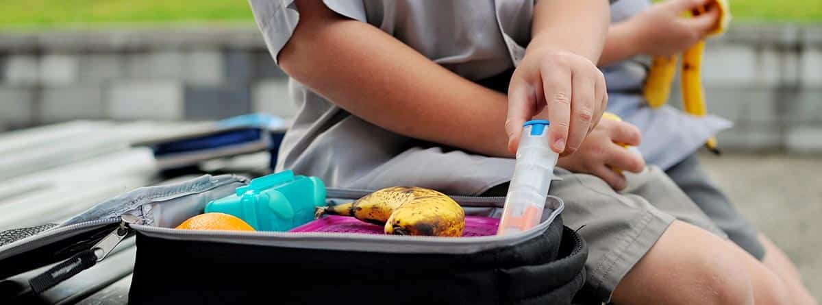 joven con una maleta llena y un tubo de adrenalina