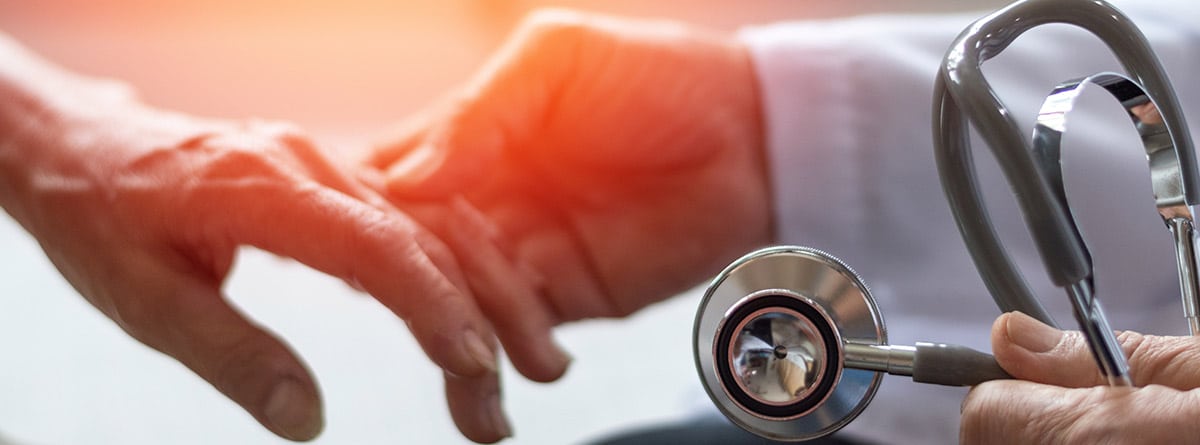 Doctor sujetando las manos a un paciente