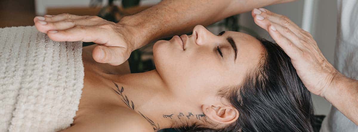 mujer mientras recibe energía en una terapia de Reiki