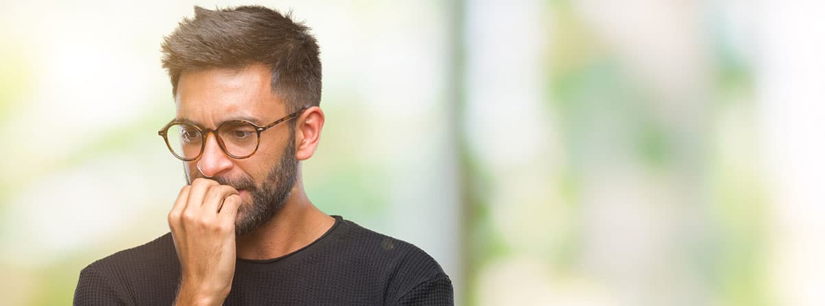 Hombre mordiéndose las uñas, con cara de preocupación