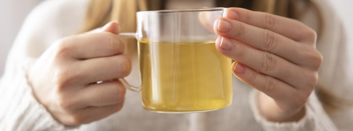 Manos de mujer sosteniendo una taza de té