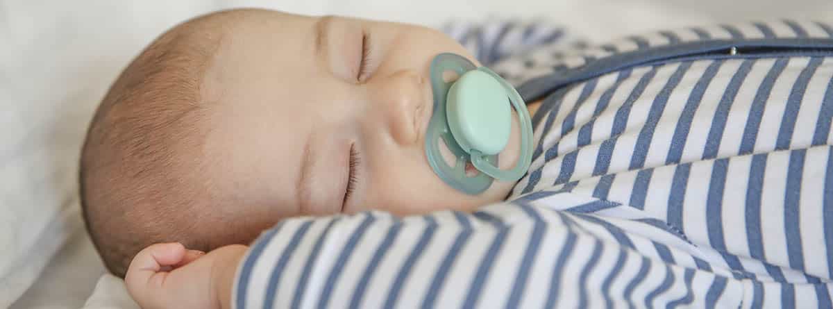 Bebé durmiendo con un chupete en la boca