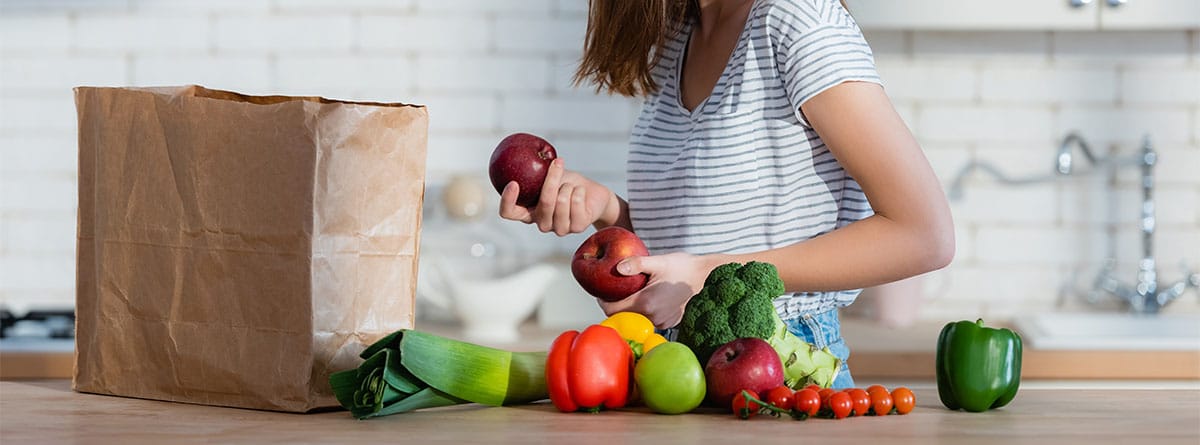 Mujer ordenando la compra con verduras