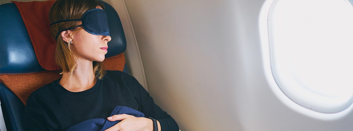 Mujer joven durmiendo en un avión