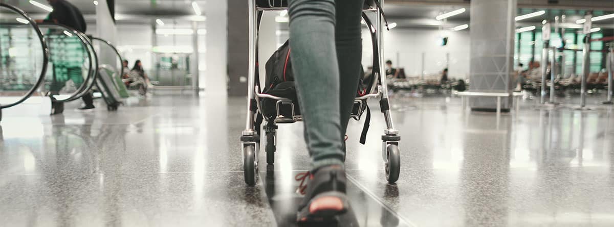 Persona empujando silla de ruedas en el aeropuerto