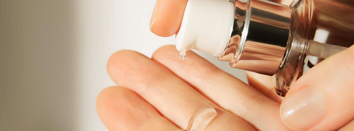 Una mano poniendo un tratamiento en crema sobre otra