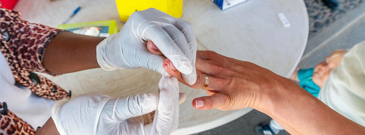 Dos manos de mujeres realizando un análisis de sangre